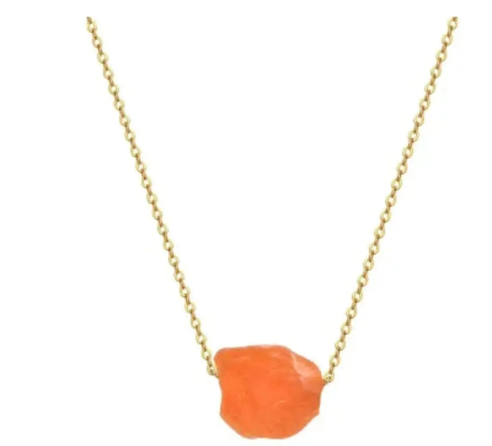 A vibrant orange raw-cut gemstone pendant on a delicate gold chain from the rainbow tree of life crystal pillar necklace