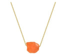 A vibrant orange raw-cut gemstone pendant on a delicate gold chain from the rainbow tree of life crystal pillar necklace