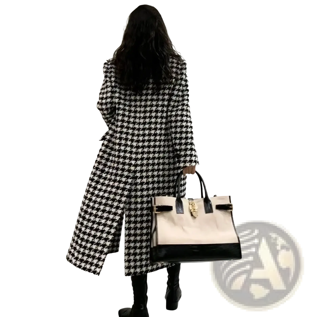 A cream and black two-tone handbag with glossy patent leather base and gold hardware, paired with a houndstooth double breasted wool coat