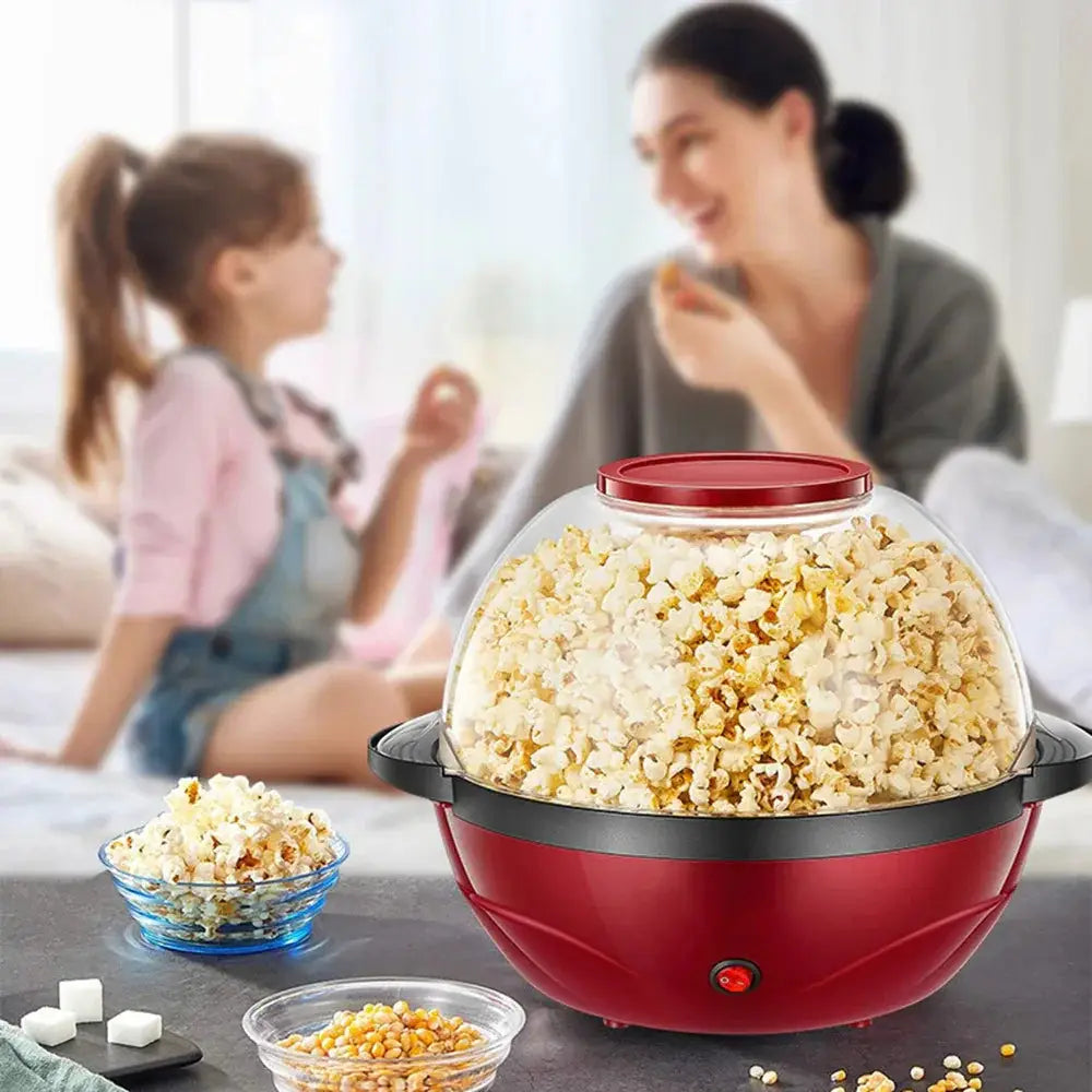 850w electric dome popcorn maker in red with clear lid and black accents filled with freshly popped popcorn