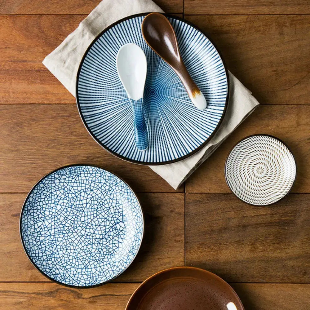 Minimalist Japanese ceramic dining set featuring blue and white plates with intricate radial crackle patterns and matching spoons