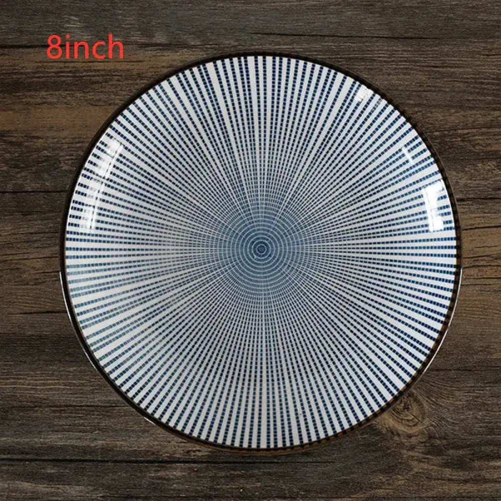 An 8-inch minimalist Japanese ceramic plate with dark blue radial lines on white and a subtle brown rim