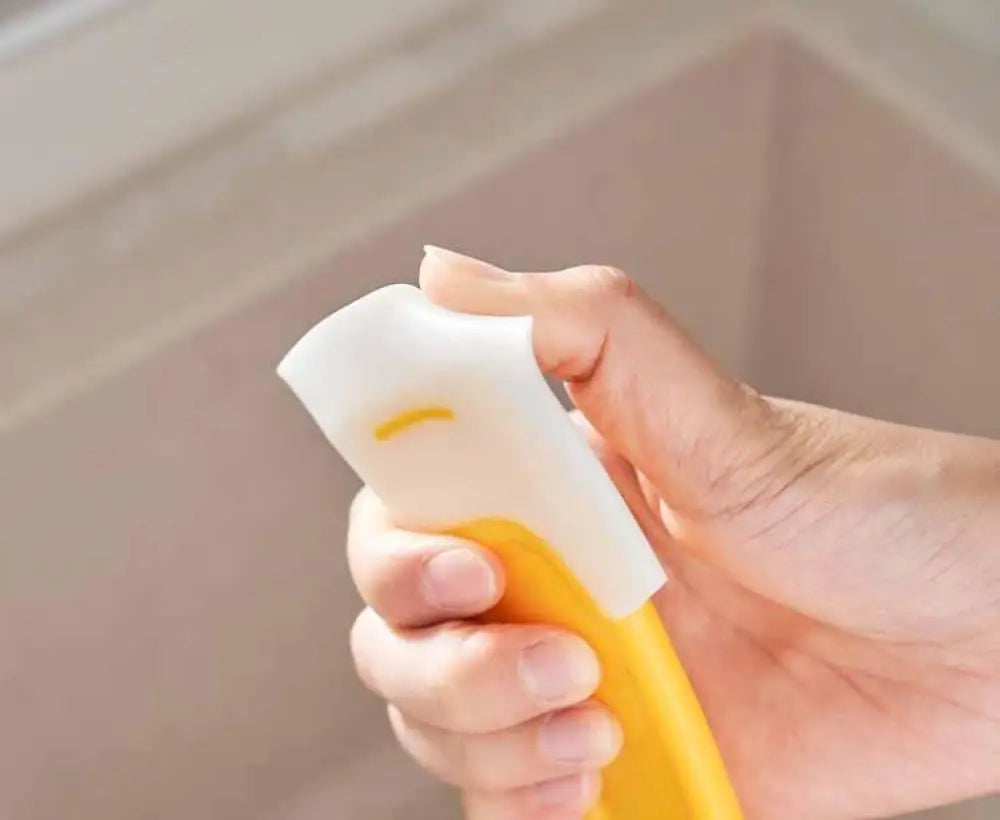 Yellow and white silicone kitchen squeegee and grease scrub brush with smiley face design for cleaning tasks