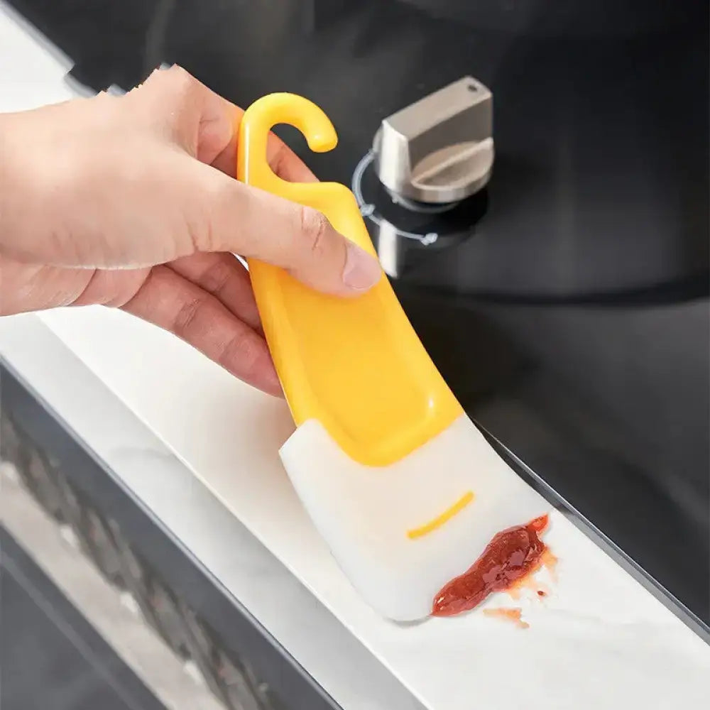 Yellow and white silicone kitchen spatula with hook handle from Smiley silicone squeegee and grease scrub brush set