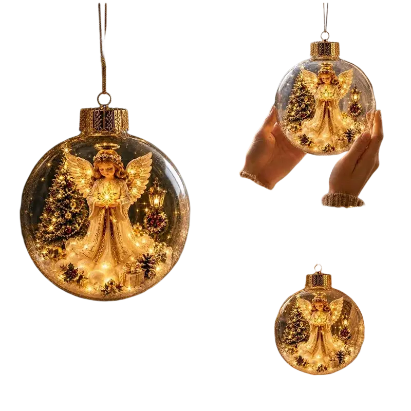 Illuminated glass Christmas ornament ball with golden angel figurine inside surrounded by miniature trees and pinecones