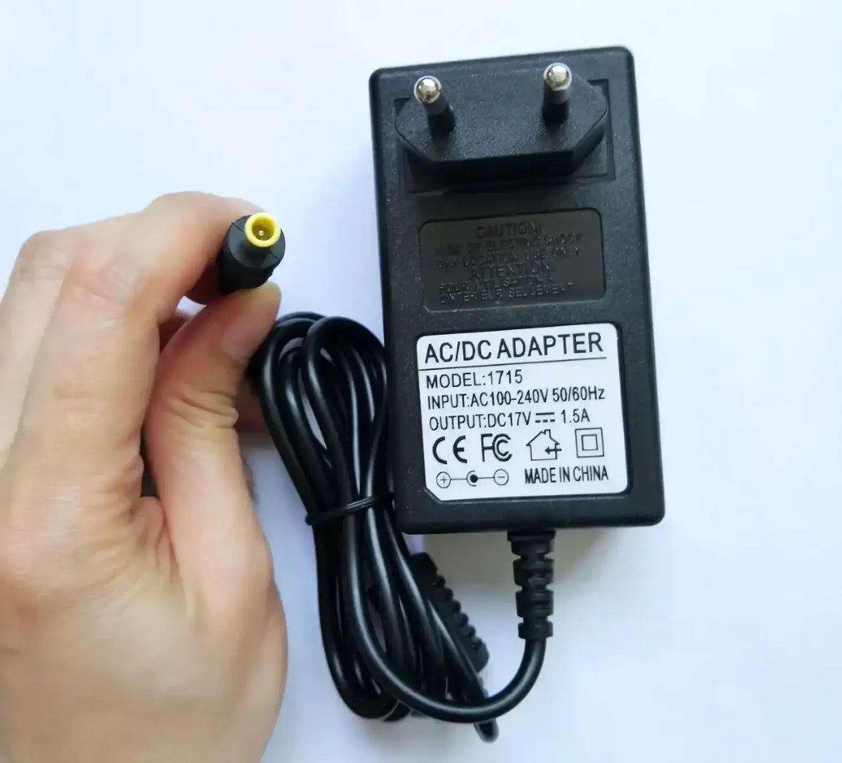 Black plastic ilsintech swift kf4a ac adapter with coiled power cord and yellow-capped dc connector for battery charging
