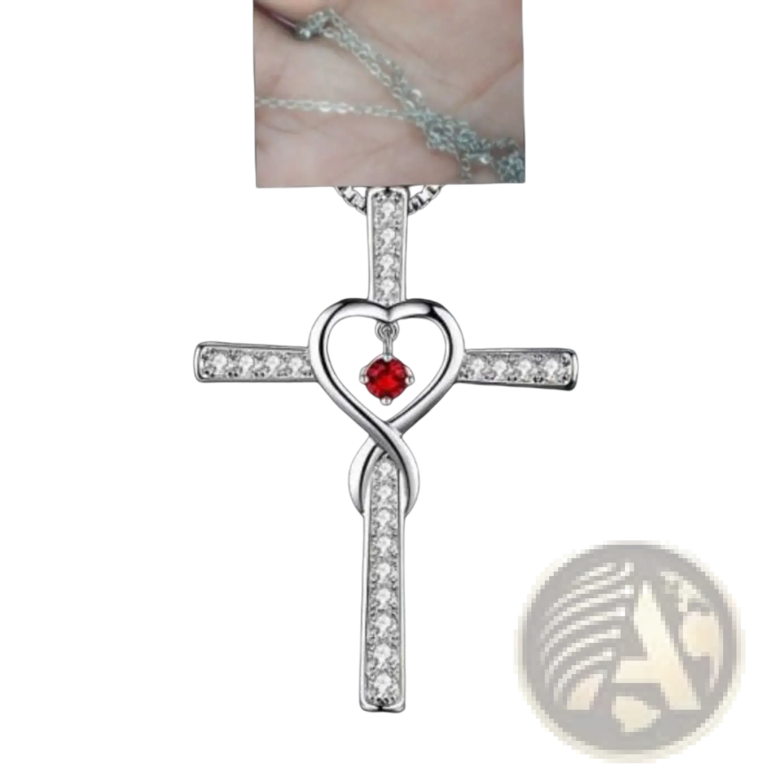 Silver cross pendant with heart-shaped infinity knot design adorned with clear crystals and a central red gemstone