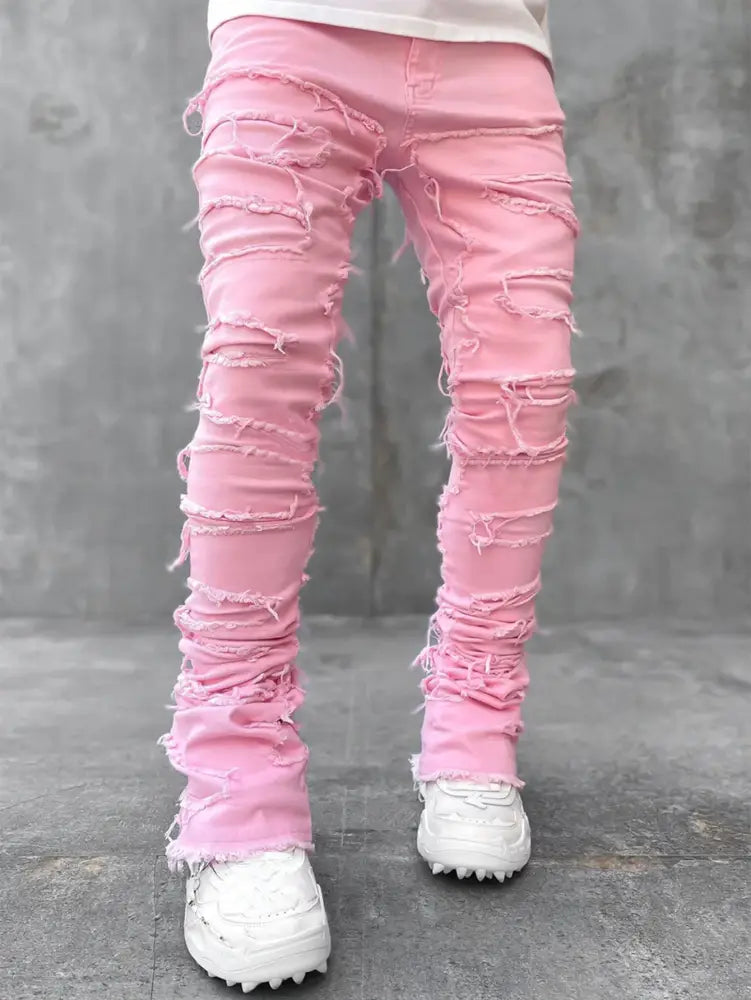 Men’s slim fit stacked ripped patchwork pink distressed denim jeans with frayed and ripped details along the legs