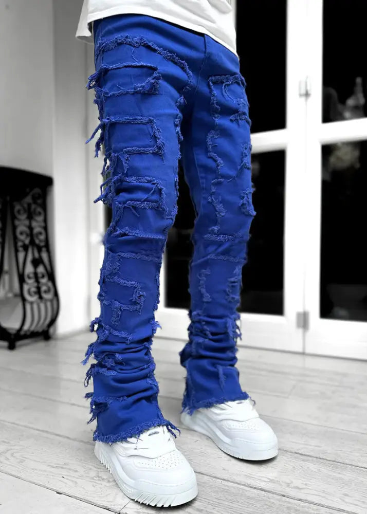 Men’s slim fit stacked ripped patchwork streetwear jeans in vibrant royal blue distressed denim with frayed detailing