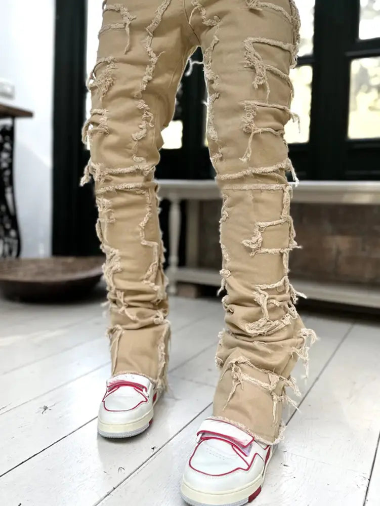 Men’s slim fit beige distressed denim jeans with frayed ripped detailing for streetwear style