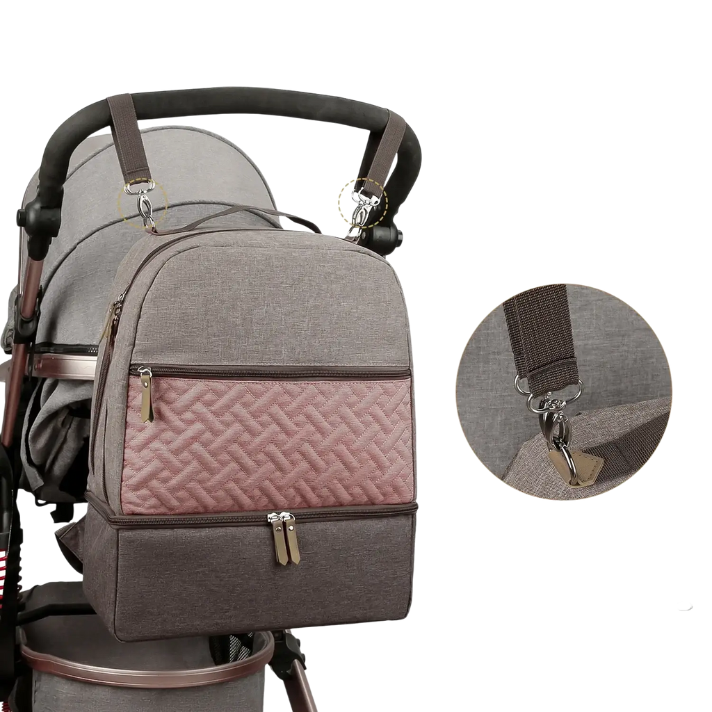 Insulated gray and pink quilted baby diaper backpack with brown zippers and metal hardware shown from the back side