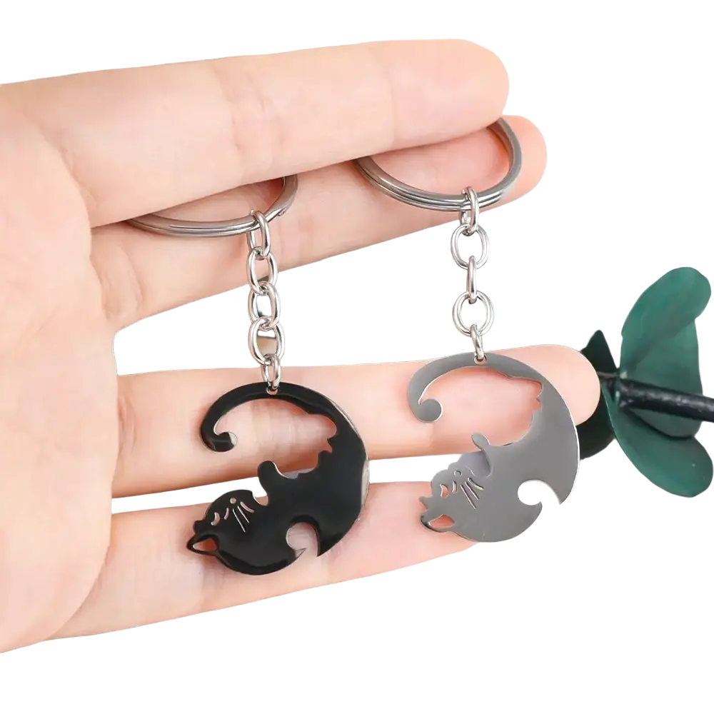 A pair of sleek minimalist interlocking cat couple keychains in black and silver metallic finishes