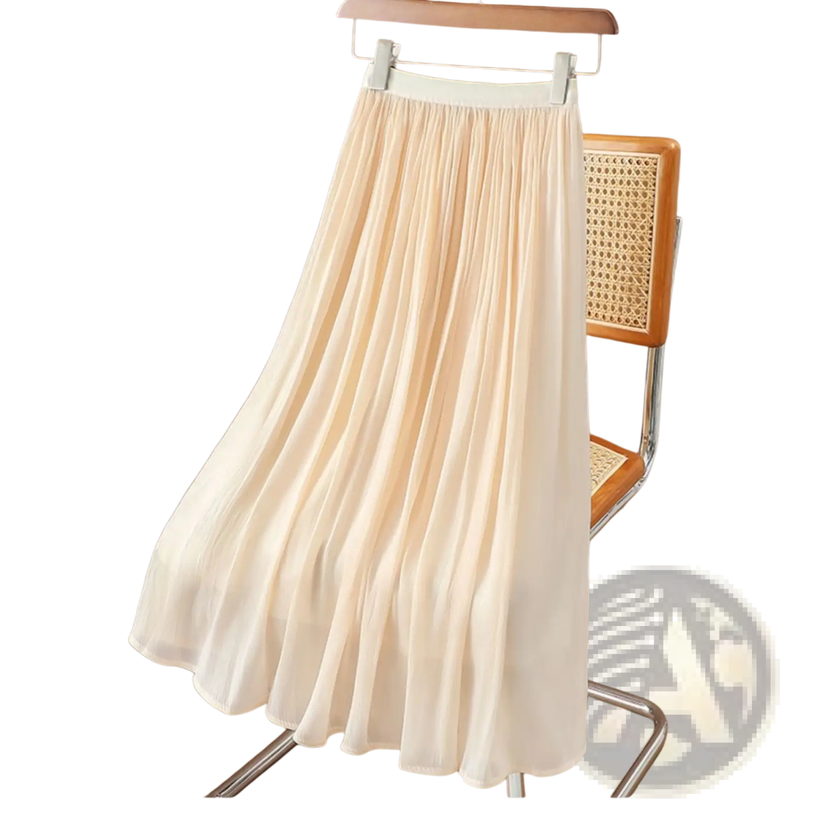 A flowing cream-colored iridescent chiffon pleated skirt made of lightweight fabric hanging on a wooden hanger