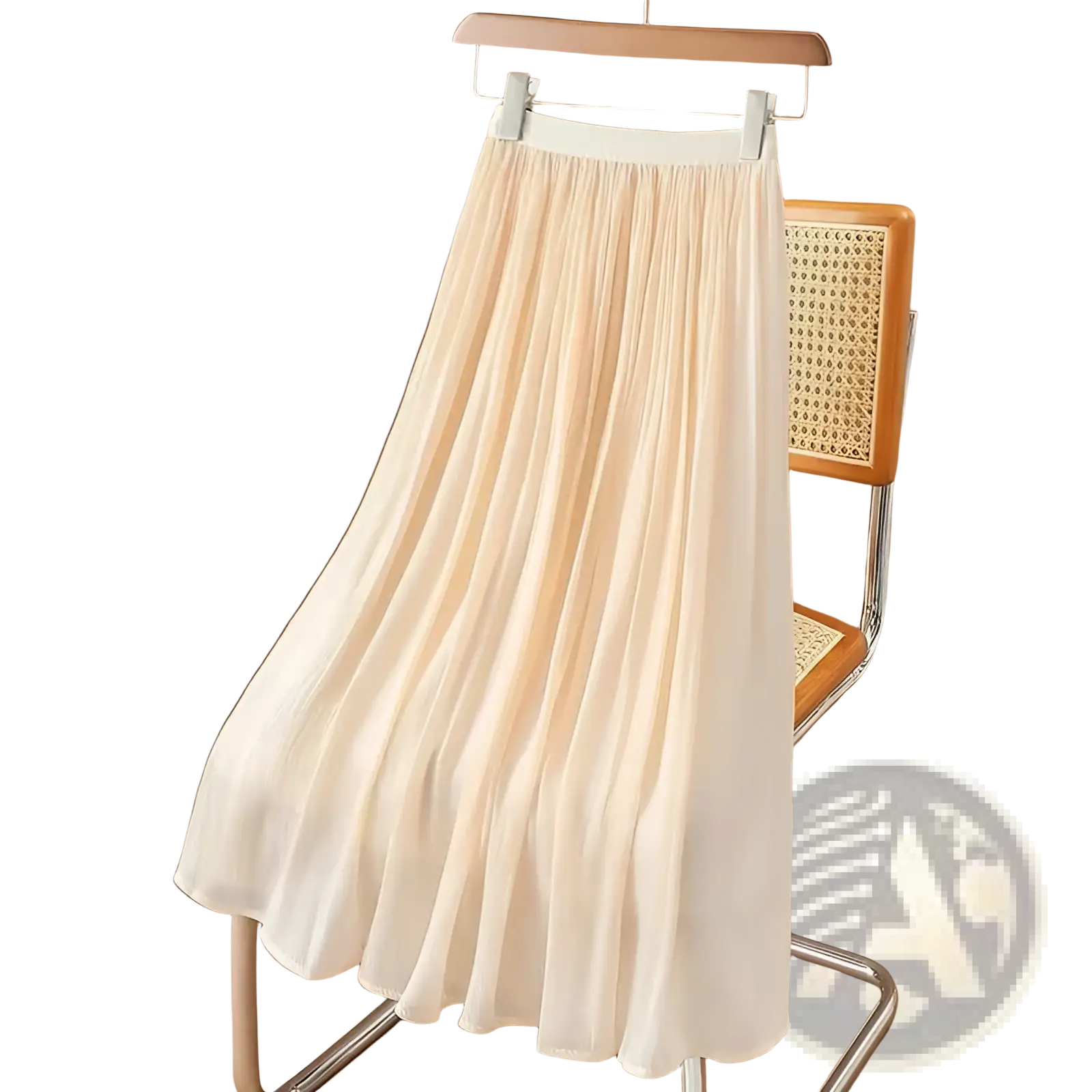 A flowing pale peach iridescent chiffon pleated skirt made of lightweight fabric hanging on a wooden hanger