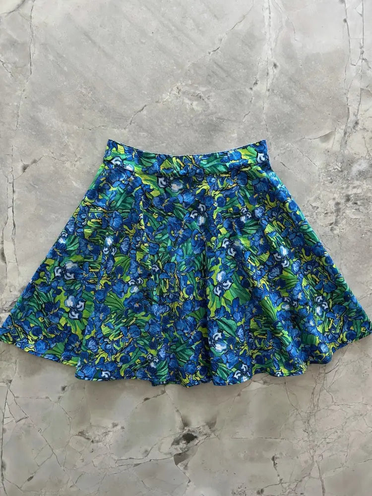A vibrant blue and green irises floral print vintage skater skirt with elastic waistband and flared design