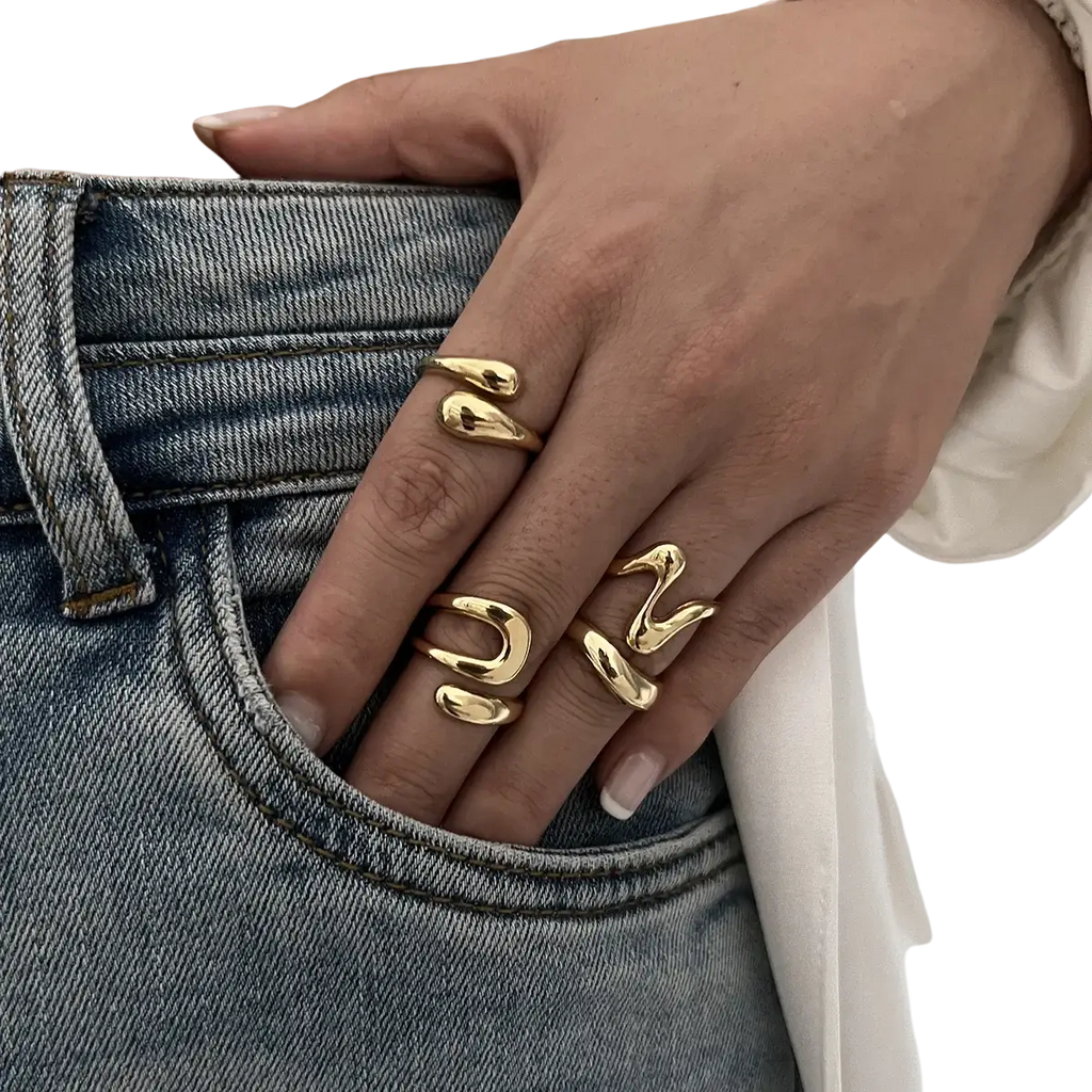 Gold-toned irregular geometric ring set with abstract design worn on fingers featuring a sleek modern punk fashion style
