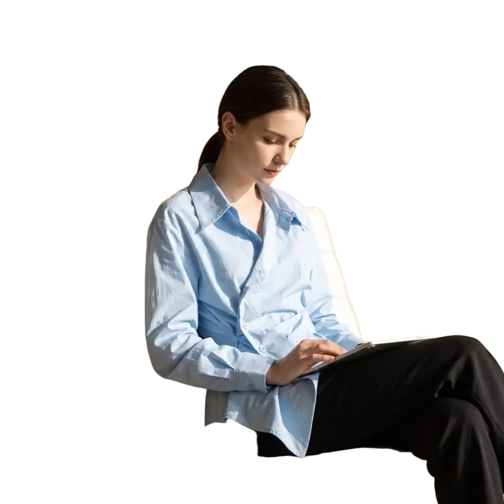 A woman wearing a light blue irregular v collar slim fit blouse sits on a modern white upholstered chair