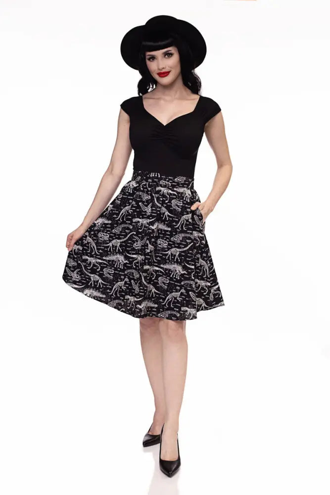Isabel retro black sweetheart neckline top paired with a black a-line skirt featuring a white dinosaur skeleton print