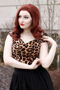 A woman wears an Isabel leopard print sweetheart neckline vintage top with v-neck cap sleeves and a black skirt