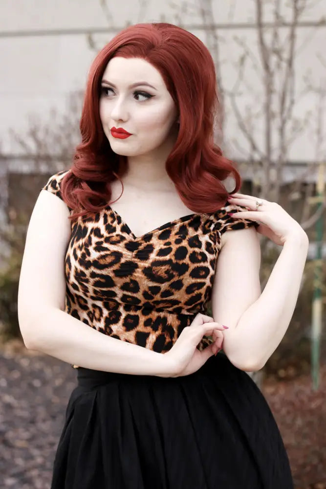 A woman wears an Isabel leopard print sweetheart neckline vintage top with v-neck cap sleeves and a black skirt