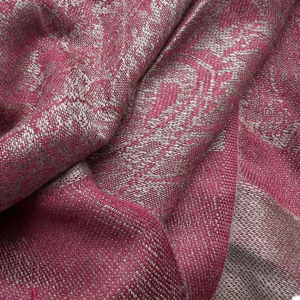 A soft jacquard winter scarf in rich pink and silver tones with a textured woven pattern