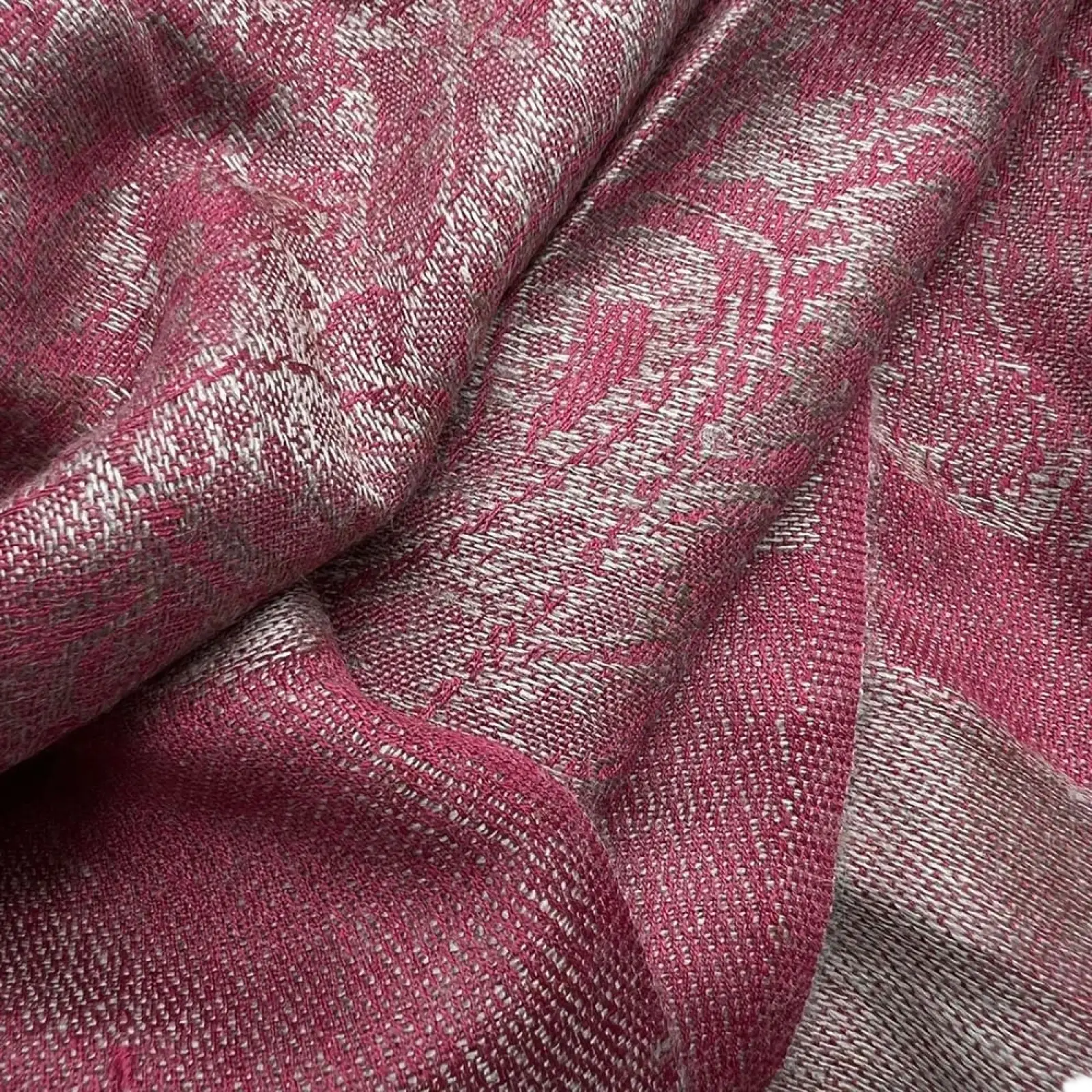 A soft jacquard winter scarf in rich pink and silver tones with a textured woven pattern