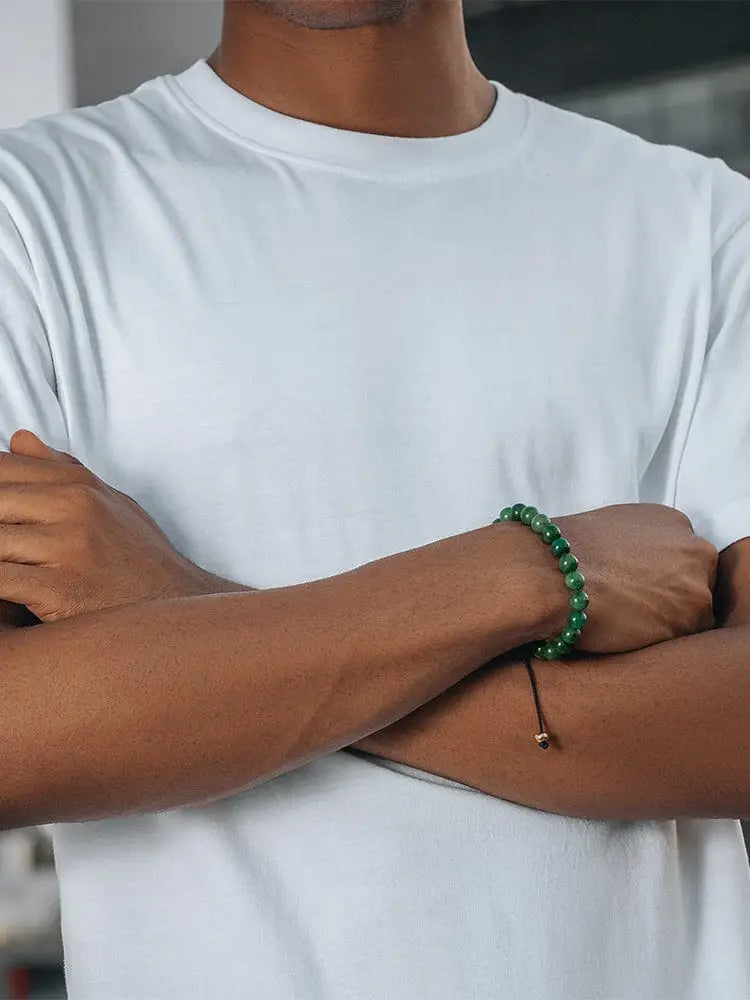 A vibrant green Bali African jade beaded bracelet with thin black cord and small gold-toned clasp