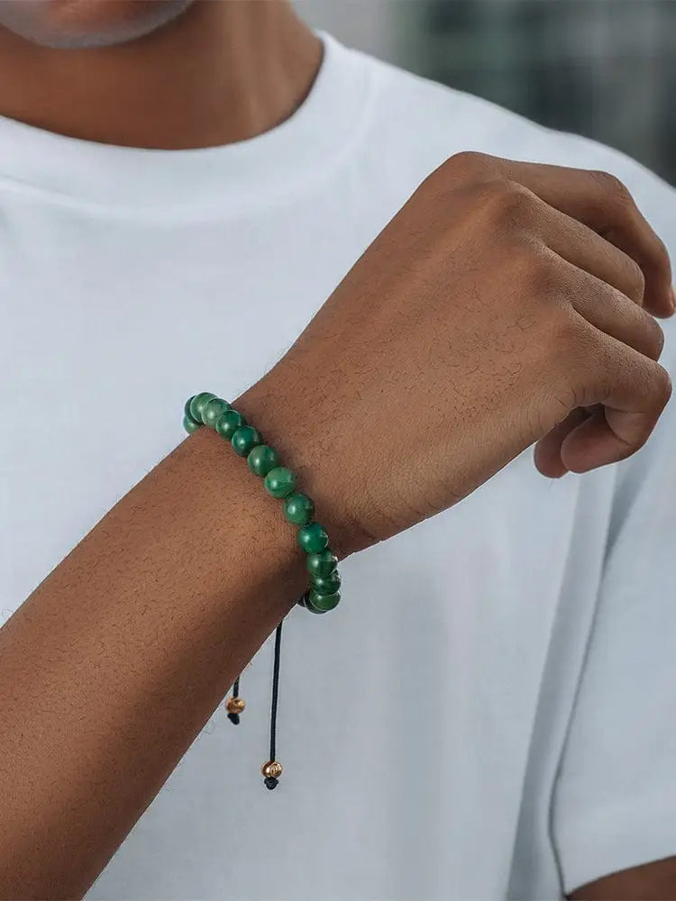 A vibrant green jade beaded Bali African bracelet with gold-toned metal beads and black cord