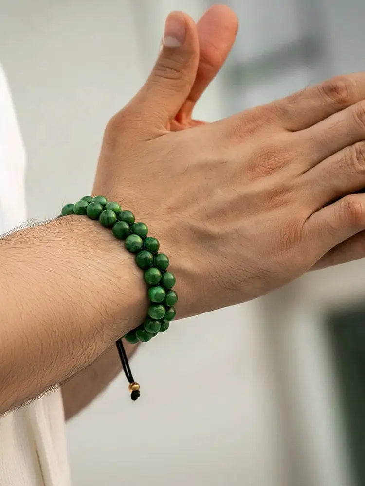 Adjustable African jade beaded bracelet with smooth green stones gold accents and black cord closure