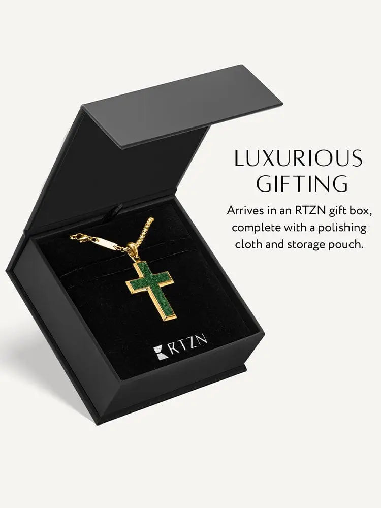 Gold stainless steel cross pendant necklace with green enamel inlay displayed on a black rtzn gift box