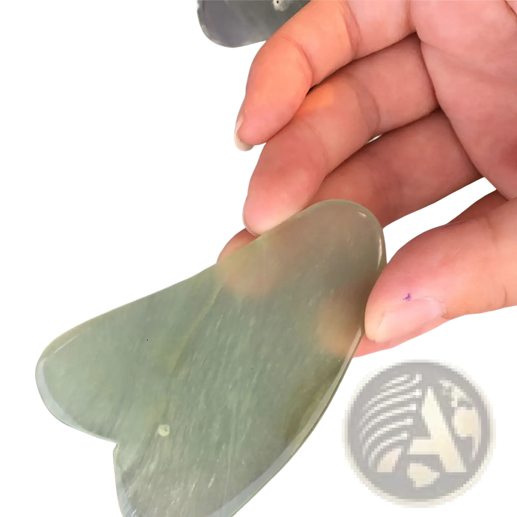 A translucent green jade gua sha facial massage tool with a smooth textured heart-shaped design for skin care
