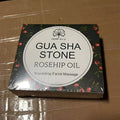 Black rectangular box with white circular label gua sha stone rosehip oil and red berries in jade gua sha facial set