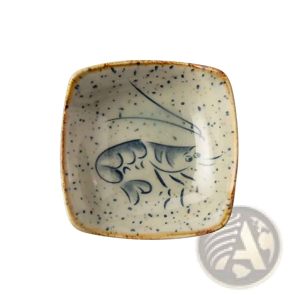 A square ceramic sea creature sauce dish with speckled beige glaze and hand-painted blue shrimp design