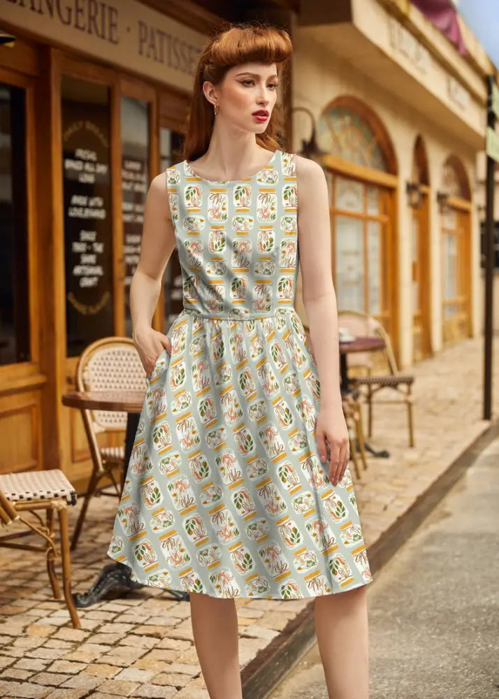 A light blue vintage 1950s cotton sleeveless dress with colorful jars print and pockets