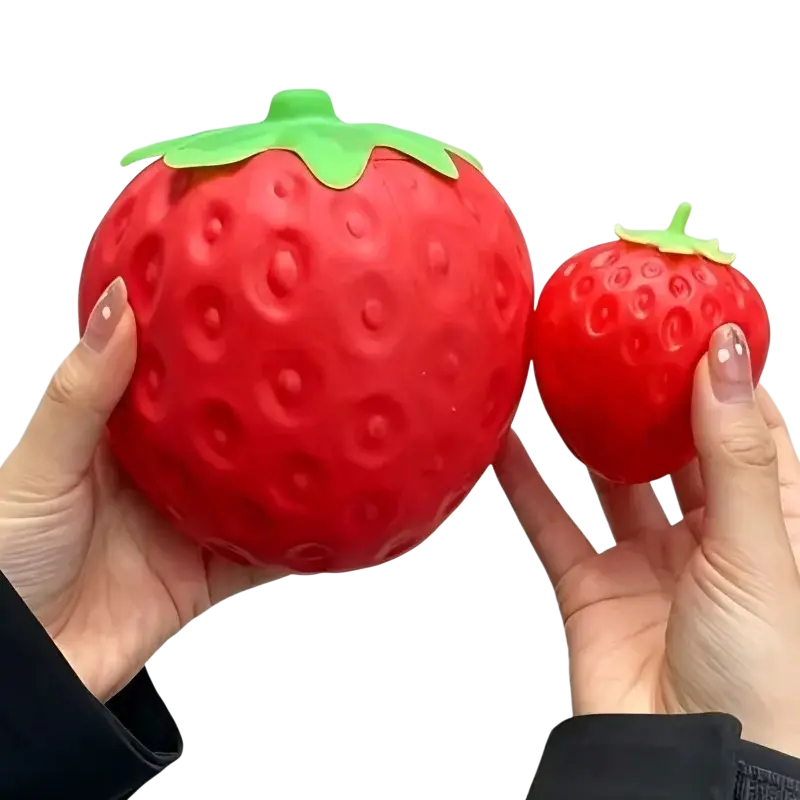 Jumbo strawberry slow rising sensory fidget toy in red silicone with green leafy top shaped like a stress ball