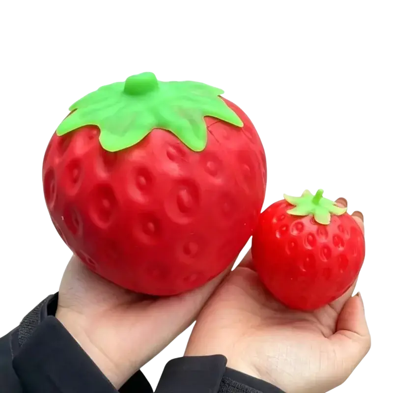 Jumbo strawberry slow rising sensory fidget toy made of textured silicone in red with a green leafy top