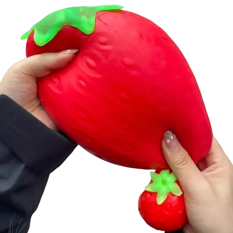 Jumbo strawberry slow rising sensory fidget toy in vibrant red with textured surface and green leafy top for stress relief