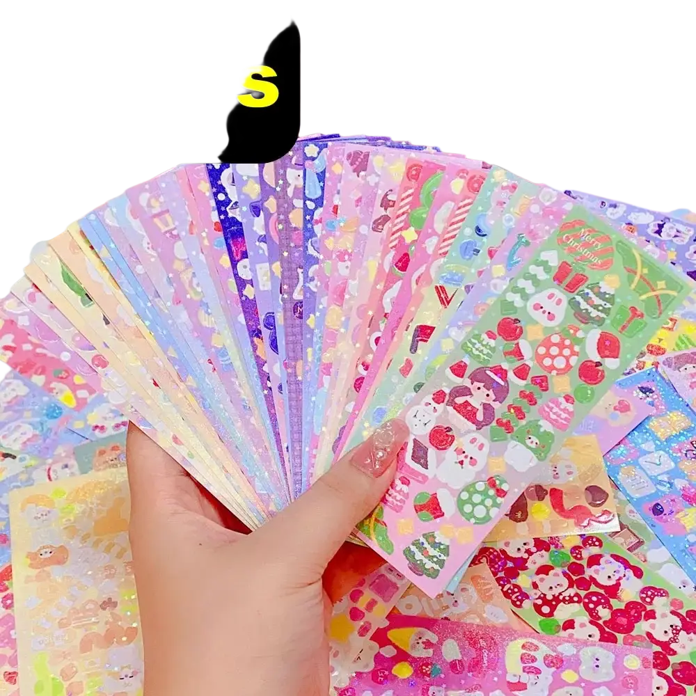 A hand holding colorful glossy kawaii cute cartoon sticker sheets for scrapbooking and diary decor