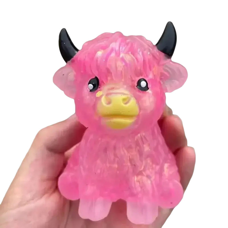 Kawaii highland cow squishy stress relief toy made of pink translucent plastic with black horns and yellow nose