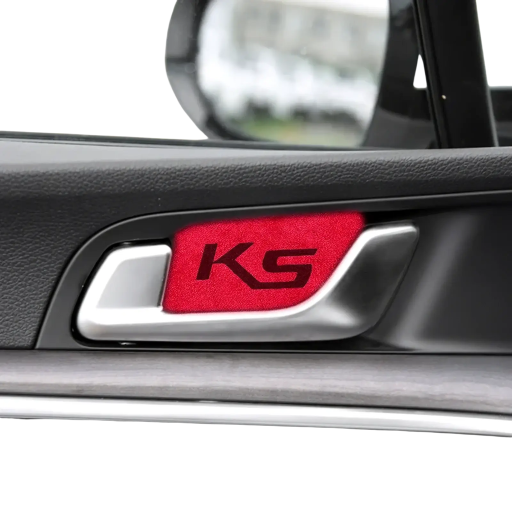 Red textured ks emblem sticker on silver kia k5 suede carbon interior door handle cover visible from front side