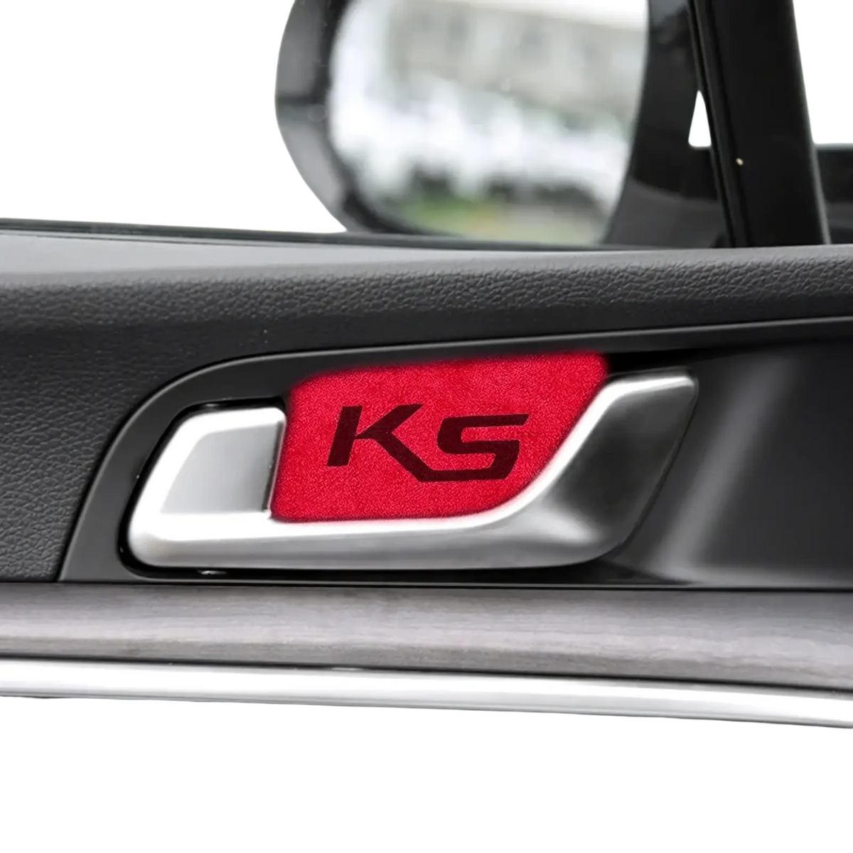 Red textured ks emblem sticker on silver kia k5 suede carbon interior door handle cover visible from front side