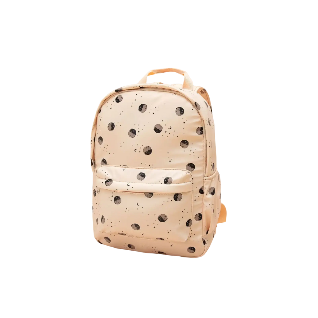 Cream-colored kids dinosaur backpack with black moon and star patterns pastel school bag front view