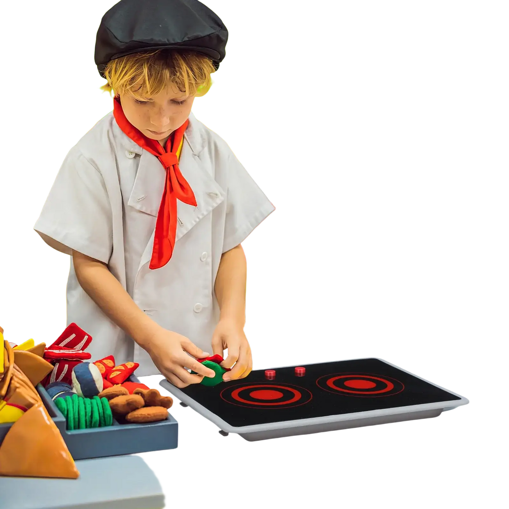 Child in chef outfit with red scarf and black hat using kids play induction stove toy with sound and light at kitchen counter
