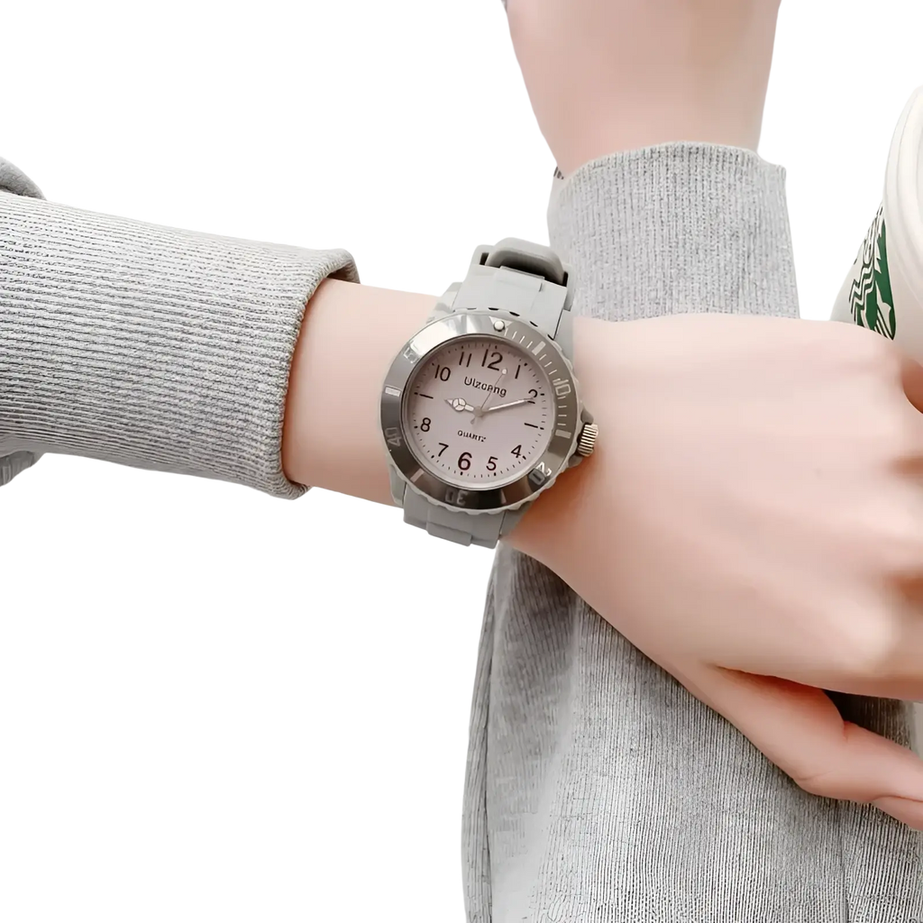 Kids silicone quartz watch with gray silicone strap, silver-toned case, and light pink dial with black arabic numerals