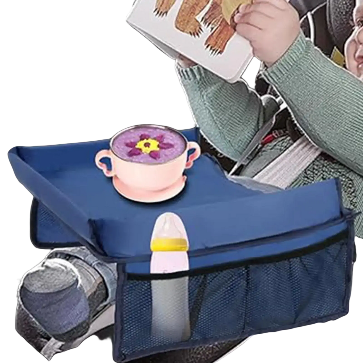 Blue fabric kids travel tray for car and airplane with mesh side pockets holding a baby bottle
