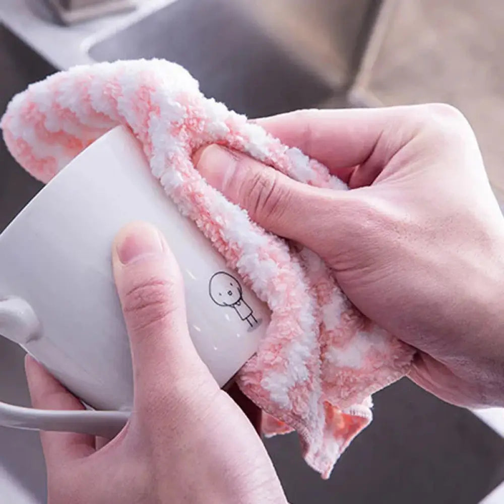 Pink and white striped super absorbent coral fleece kitchen cleaning cloth wiping a white ceramic mug with cartoon design