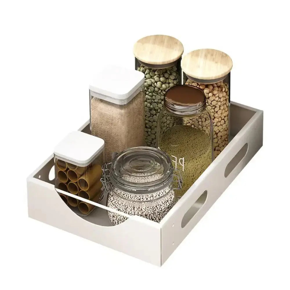 White rectangular storage tray with cutout handles holding glass jars as adjustable white kitchen drawer dividers