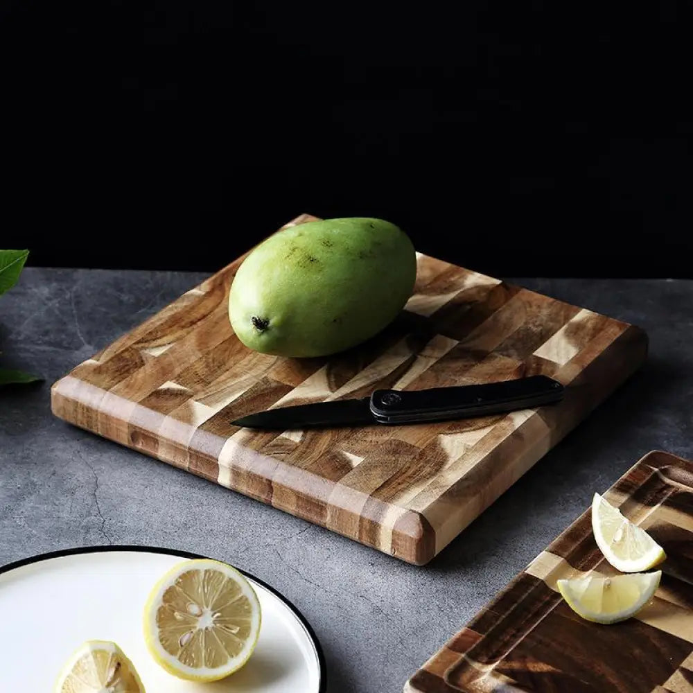 A striped parquet solid wood cutting board with light and dark wood tones featuring a green mango