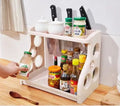 White plastic two tier kitchen spice and utensil organizer rack with circular cutouts and integrated knife holders
