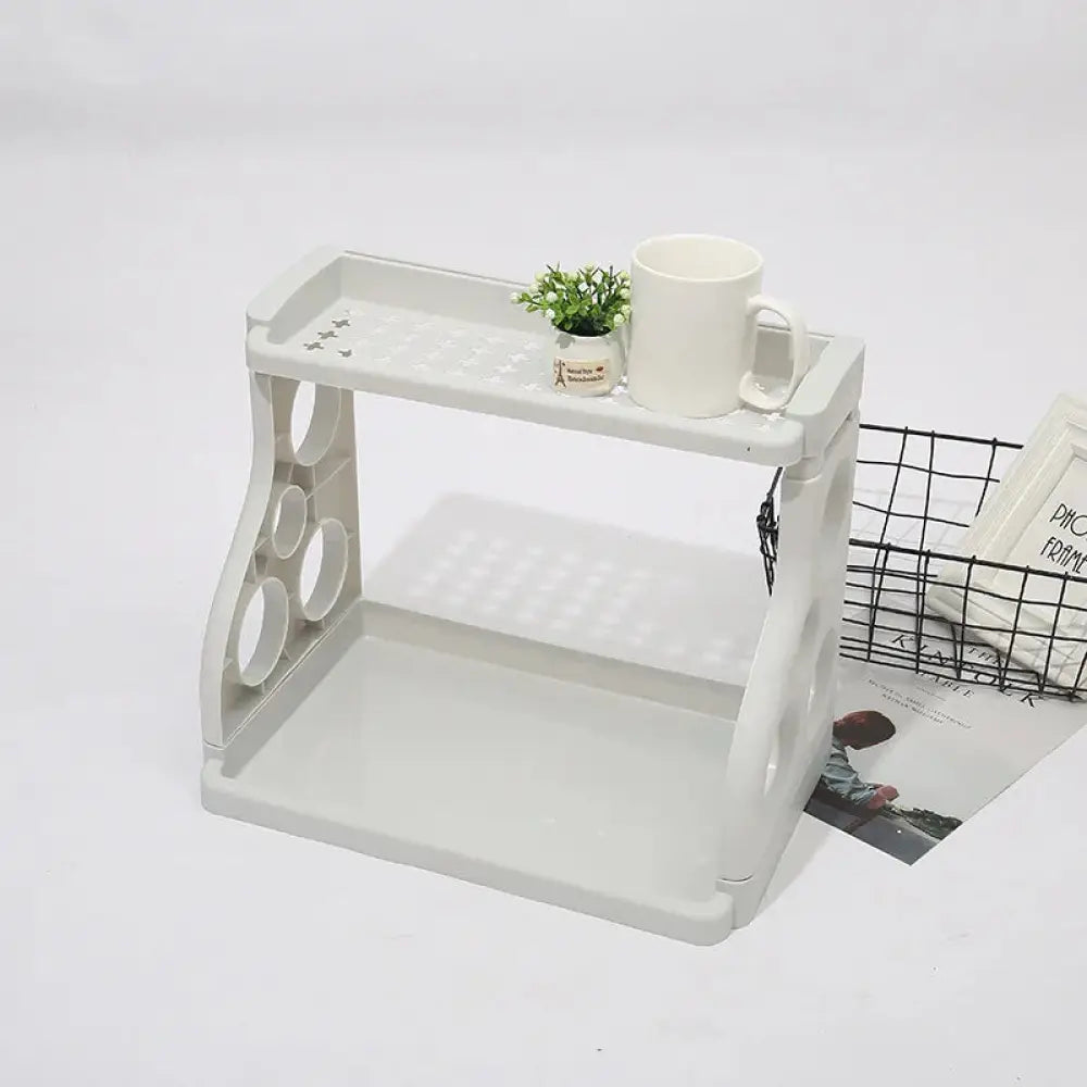 White plastic multilayer two tier kitchen spice and utensil organizer rack with circular cutouts and textured surface